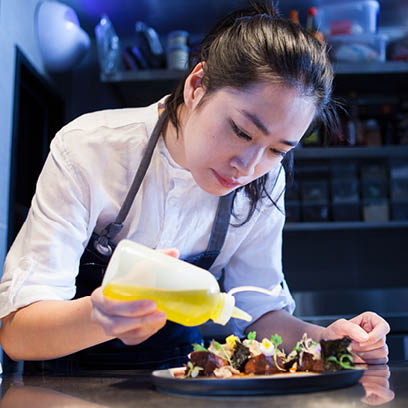 Chef dressing prepared meal