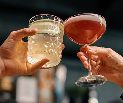 Close up of two people cheering cocktails in bar or disco club drinks and cocktails concept