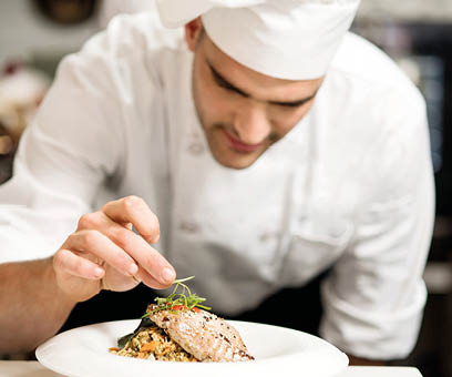 Male chef garnishing his dish, ready to serve