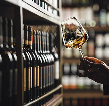 Close-Up of Sommelier Tasting White Wine in Dimly Lit Cellar