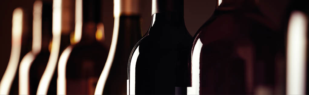Bottles of old aged wine collection in a row in winery cellar